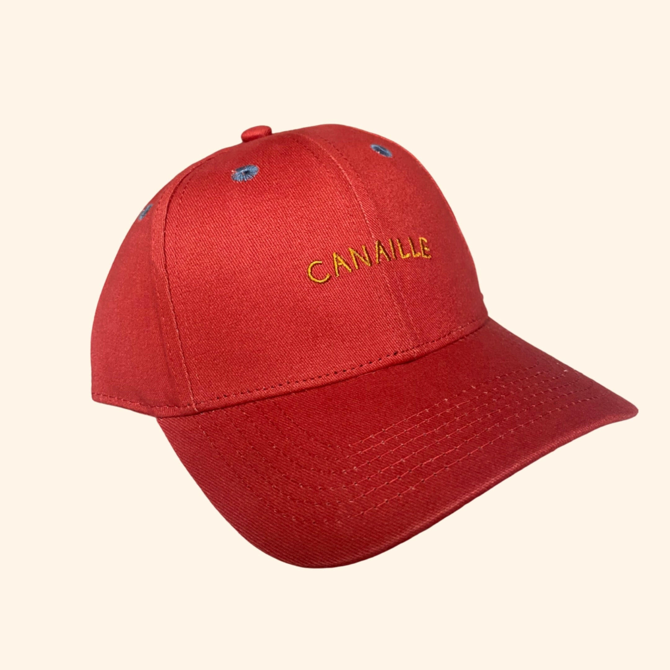  casquette pour enfant est parfaite pour compléter le look de votre petit bout avec style et confort. De couleur rouge, elle est agrémentée d'une broderie jaune "Canaille" 