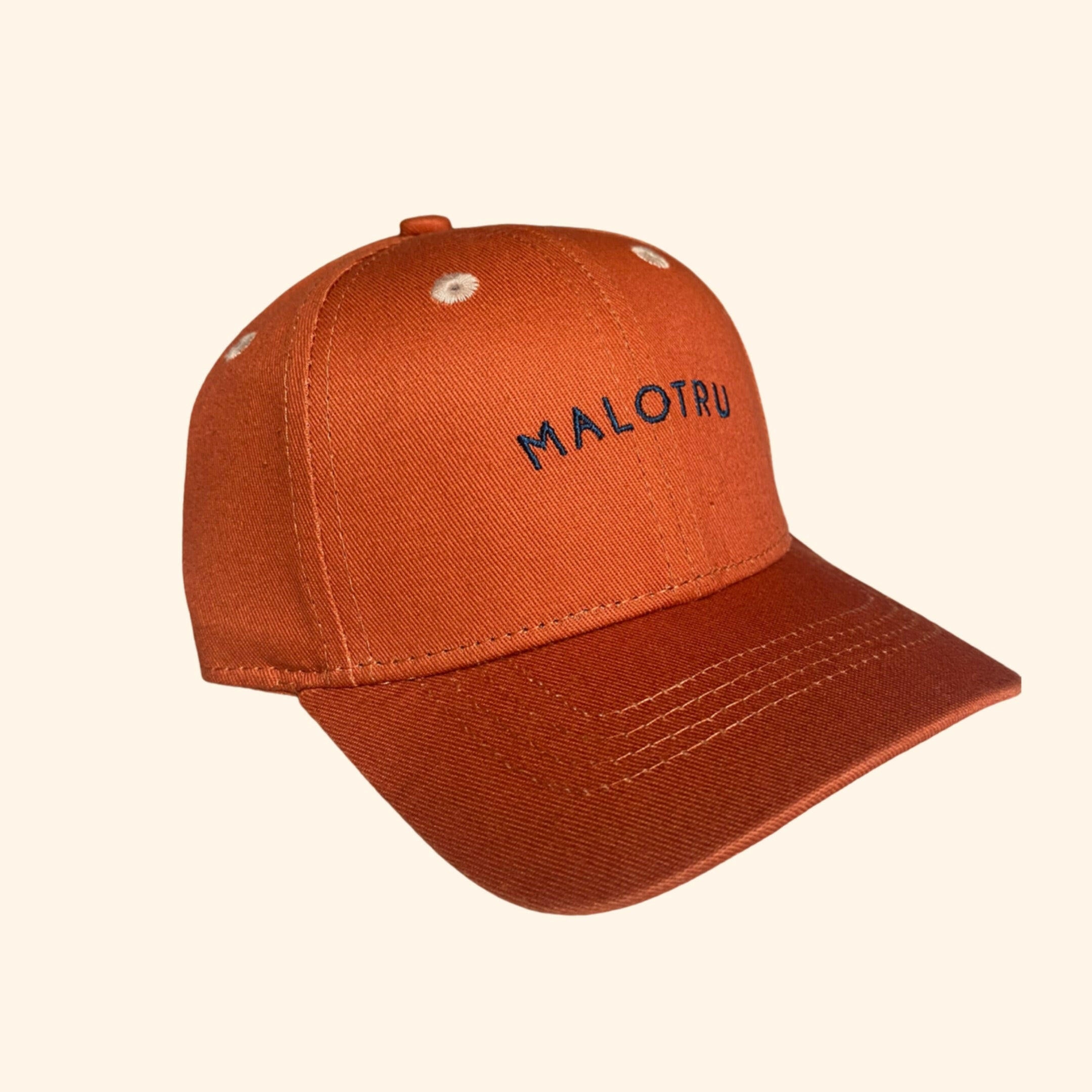 Cette adorable casquette pour bébé est parfaite pour compléter le look de votre petit bout avec style et confort. De couleur orange, elle est agrémentée d'une broderie bleue malotru