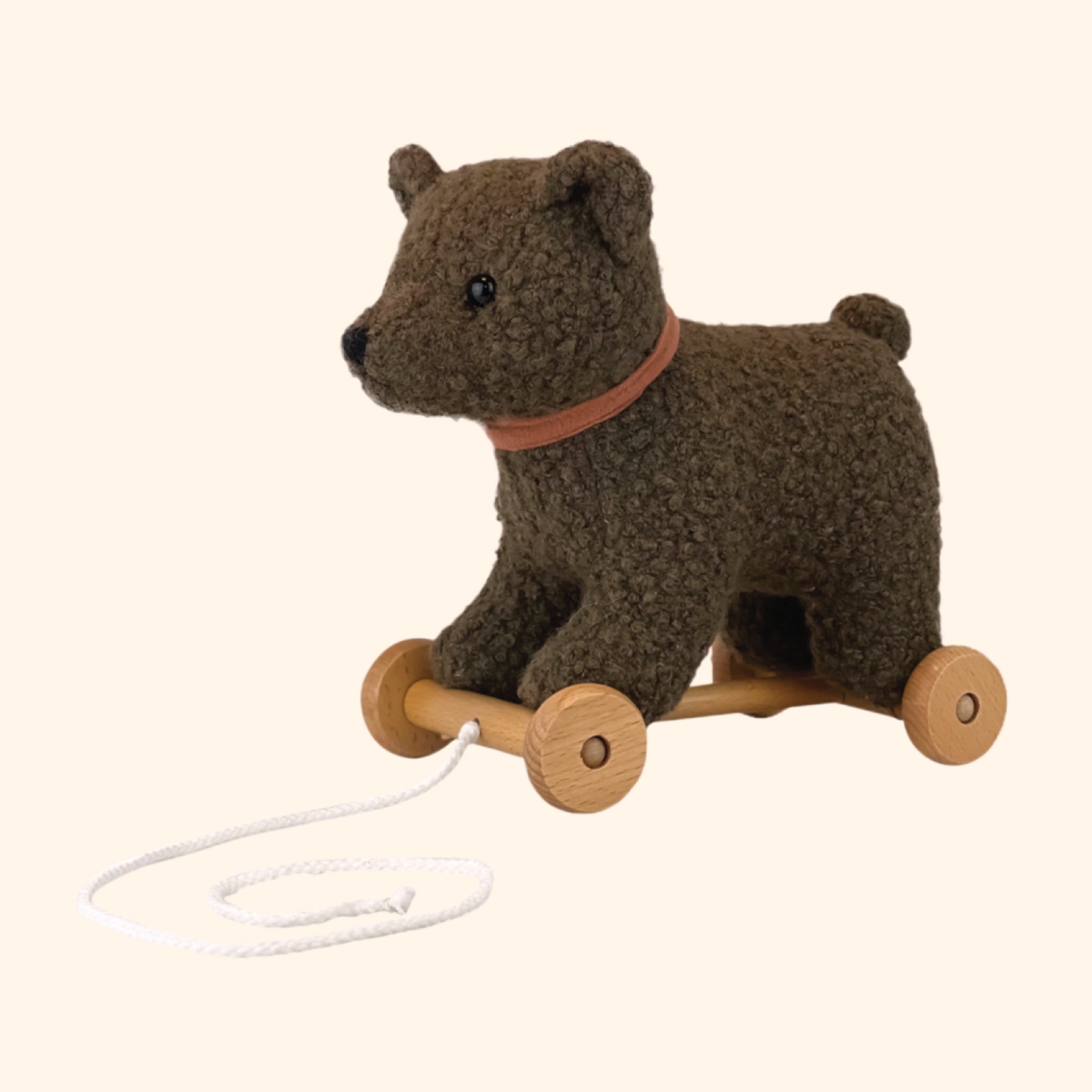 Découvrez Raoul, l'ours à tirer en peluche douce avec une base en bois. Un jouet câlin et ludique, idéal pour les enfants de tout âge !